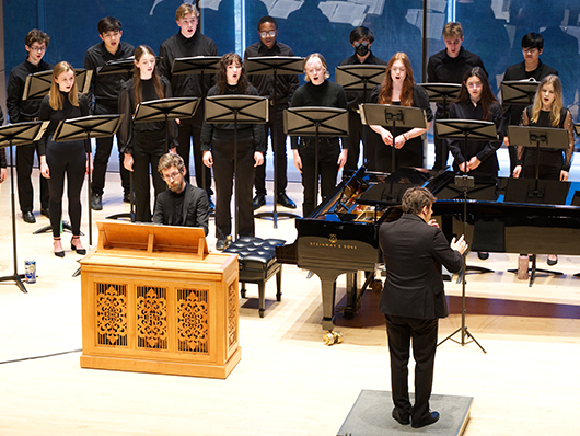 Singers and a keyboardist performing onstage