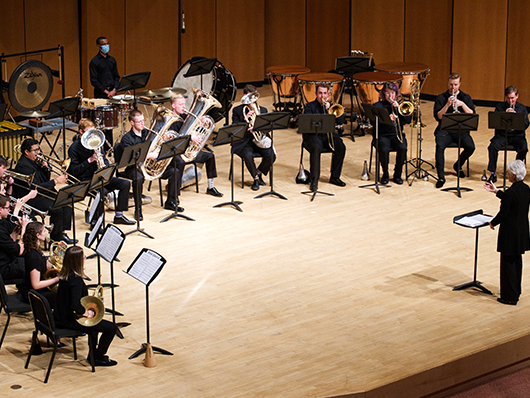 Brass musicians performing in a semicircle onstage