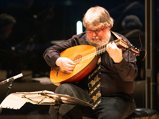 Paul O'Dette performing onstage with a lute