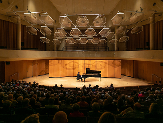 Jeffrey Siegel seated at a grand piano in front of an audience on the Pick-Staiger Concert Hall stage