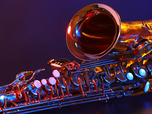 A saxophone lit with red and blue lighting.