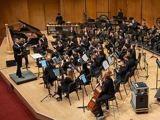 Roberty Taylor conducts the Symphonic Wind Ensemble onstage.