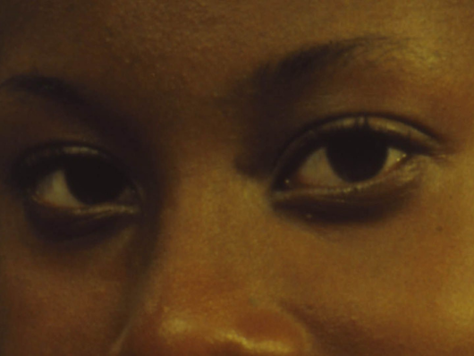 Close up on woman's dark brown eyes gazing head-on