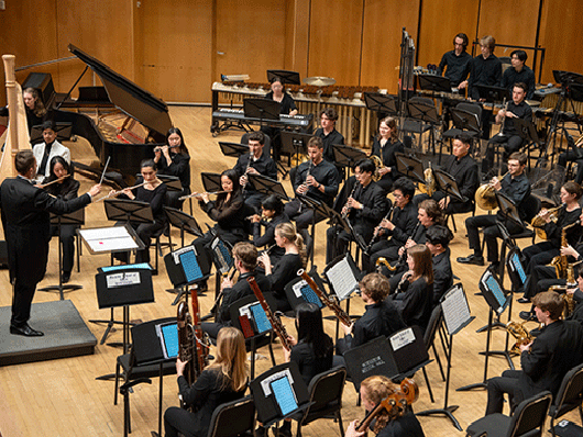 The Symphonic Wind Ensemble performs onstage.