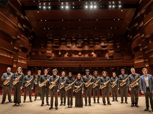 The saxophone ensemble stands in a row onstage.