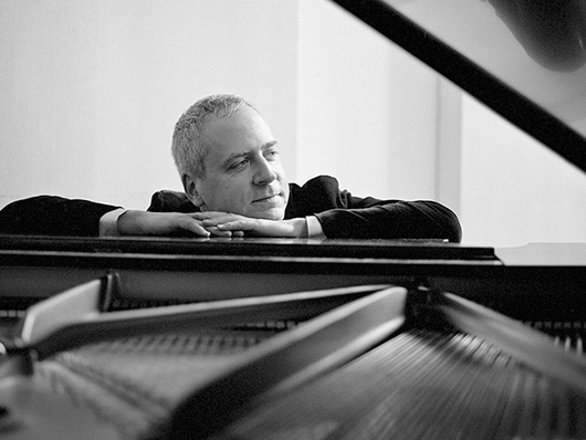 Jeremy Denk at the piano in black and white.