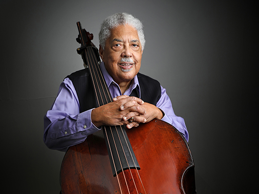Rufus Reid sits with his upright bass.