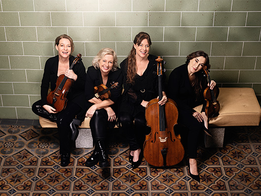 Vertavo String Quartet sits, smiling.