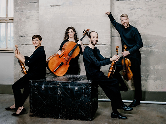 Ariel Quartet sits, smiling.