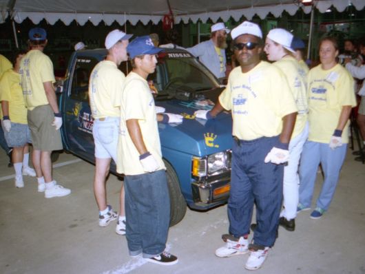 People wearing yellow shirts must keep one hand on a truck