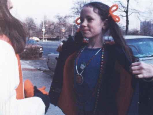 A young girl opens a fur coat