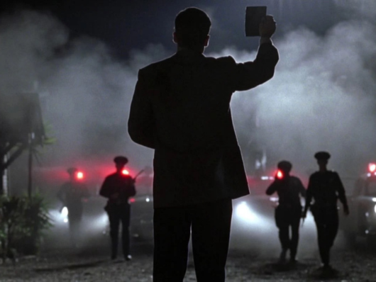 Silhouette of man holding up ID