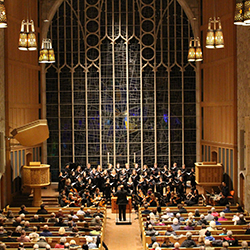 Alice Millar Chapel with audience members watching a conductor and musicians perform on stage