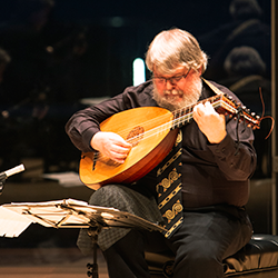 Paul O'Dette performing onstage with a lute