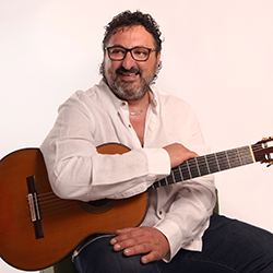 Aniello Desiderio smiling with his guitar