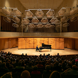 Jeffrey Siegel seated at a grand piano in front of an audience on the Pick-Staiger Concert Hall stage