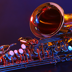 A saxophone lit with red and blue lighting.