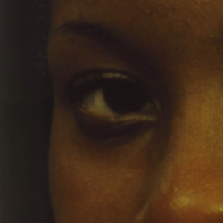 Close up on woman's dark brown eyes gazing head-on