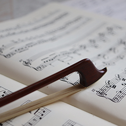 A bow sits on sheet music.