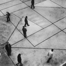 People walking in various directions in an outdoor plaza