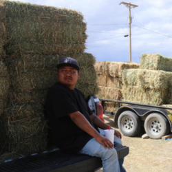 man sitting on hay truck
