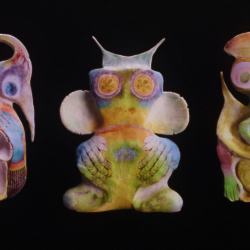 three colorful figurative sculptures on black background