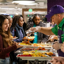 staff serving student breakfast food